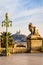 A statue of child and lion in Marseille, France, with Notre-Dame de la Garde basilica in the distance