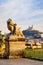 A statue of child and lion in Marseille, France, with Notre-Dame de la Garde basilica in the distance