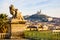 A statue of child and lion in Marseille, France, with Notre-Dame de la Garde basilica in the distance