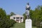 Statue of a collective farmer on a pedestal. The legacy of the Soviet era. A flower bed with tulips and young trees in