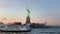 Statue Cruises ferry at sunset with the Statue of Liberty in the back