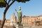 Statue of the Emperor Trajan with seagull on his head with Trajan`s Forum and market on background, Rome,