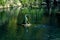 A statue is the focal point of this image, with water spraying from its mouth into a pond. Gushing seal sculpture on a park pond