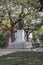 A statue of General James Edward Oglethorpe at Franklin Square with lush green weeping willow trees, plants and grass in Savannah