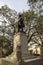 A statue of General James Edward Oglethorpe at Franklin Square with lush green weeping willow trees, plants and grass in Savannah