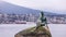 A statue of a girl in a swimsuit on a boulder on a shore of Vancouver Harbor