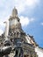 A statue of a guard in front of the magnificent spire of the Wat Arun Temple, Temple of Dawn, in Bangkok, Thailand, against blue