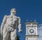 The statue of Hercules with the clock tower of the San Giovanni colonnade, Piazza della LibertÃ , Udine, Friuli, Italy