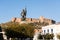 The statue of Hernan Cortes with castle of Medellin in the background, Extremadura, Spain.