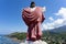 A statue of Jesus Christ laid on a hill, facing the ocean and a village in Flores, East Nusa Tenggara, Indonesia