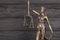 The Statue of Justice - lady justice or justitia the Roman goddess of Justice. Statue on black wooden wall. Concept of judicial