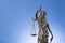 The statue of justice Themis or Iustitia on blue background