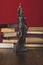 statue lady justice on wooden table with books,