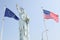 Statue of liberty with flags of europe and usa in the wind