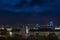 Statue of Liberty in front of illuminated Olympic Rings and Rainbow Bridge at night.