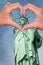Statue of liberty and hands forming a heart, New York love and travel concept