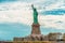 Statue of Liberty on Liberty Island, New York City. Cloudy Blue Sky Background