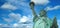 Statue of Liberty panorama with bright blue cloudy sky, New York