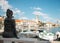 Statue of a little girl pointing at the belltower in the coastal small town of Sutivan on the island of Brac, Croatia. Wide shot