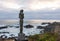 Statue of lovers, next to a general image of the Pacific Ocean coast, from the tourist town of Las Cruces, on the Chilean coast