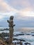 Statue of lovers, next to a general image of the Pacific Ocean coast, from the tourist town of Las Cruces, on the Chilean coast