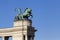 Statue of a man on a chariot, symbol of war, on a colonnade in Heroes Square, Budapest