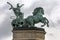 The statue of a man holding a snake driving his horse drawn chariot a symbol of war in Hero`s Square in Budapest in Hungary.