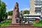 Statue of Mikhail Lushpa in the city park Kazka in Sumy. Bronze man sits on a bench among granite