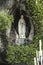 Statue of Our Lady of Immaculate Conception with a rosary in the Grotto of Massabielle in Lourdes