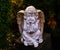 Statue of a peaceful angel child in the garden close-up. Stone cherub.