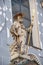 Statue of pilgrim priest with a cross, lion and book at the main facade of St. Peter`s Catholic Church in Vienna downtown, Austri