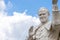 Statue of pope John Paul II blessing people, with cloudy sky in