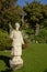 Statue of a priest in front of Jesus on the cross with Mary and Mary Magadelen kneeling next to it