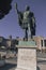 statue of a roman soldier stands in front of a castle