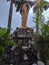 Statue of Swami Vivekanand on the decorative rocks with green leaves and plants all around