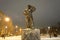 Statue to the fireman in park at winter night