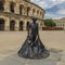 Statue of torero with the roman arena of Nimes, Southern France in background