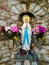 Statue of virgin mary colourfull flowers holy Madonna