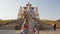 Statue of white elder with colored flags with mantras at foot of central khurul