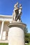 Statue of young ladies standing on tall pedestal