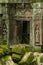 Statues and fallen rocks beside temple doorway