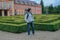 Statues of French garden of the Dobris Chateau. Tourist on background of the Maze of bushes.