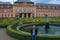 Statues of French garden of the Dobris Chateau. Tourist on background of the Maze of bushes.