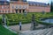 Statues of French garden of the Dobris Chateau. Tourist on background of the Maze of bushes.