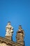 Statues on roof of St. Francis of Assisi church in Prague with blue sky in background