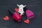 Statuette of an angel, paper hearts and two bottles of varnish on the black background