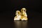 The statuette of two puppy dogs on a black background.