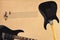 Stave and black electric rock guitar and back of guitar body on rough cardboard background.