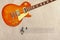 Stave and honey sunburst vintage electric guitar at the top of rough cardboard background