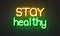 Stay healthy neon sign on brick wall background.